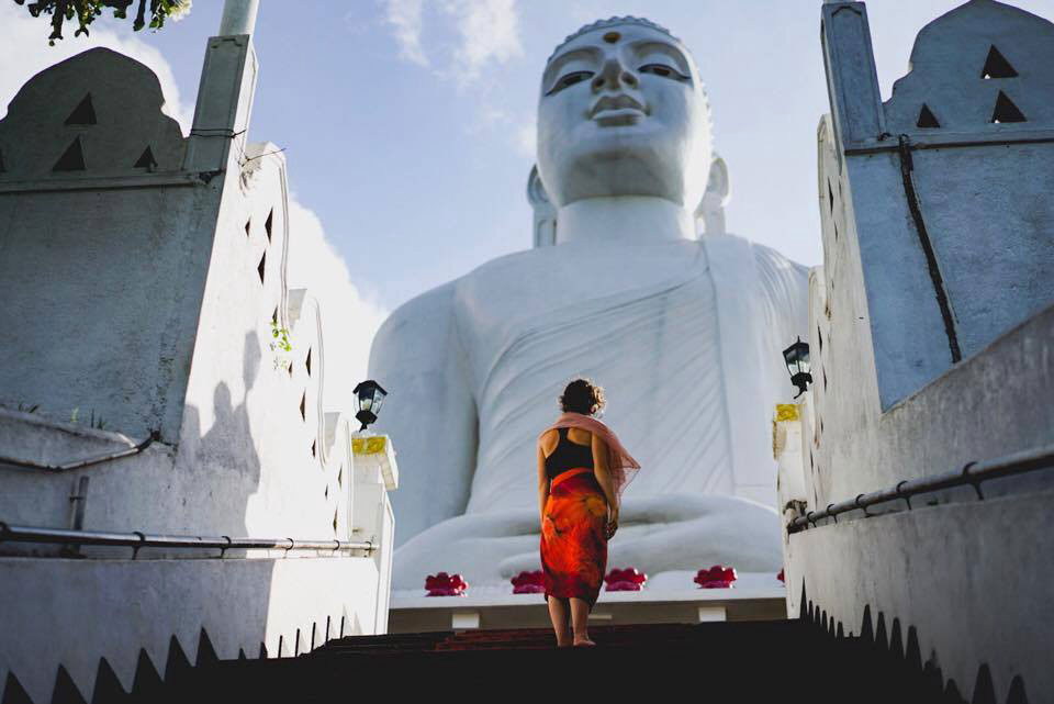 photo of woman in front of buddha statue